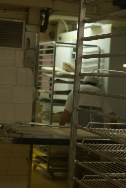 Baker moving trays of risen dough, Baluard bakery, Barceloneta. June 20, 2012.